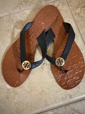 Tory Burch Black Leather Flip Flops with Gold Logo Medallions